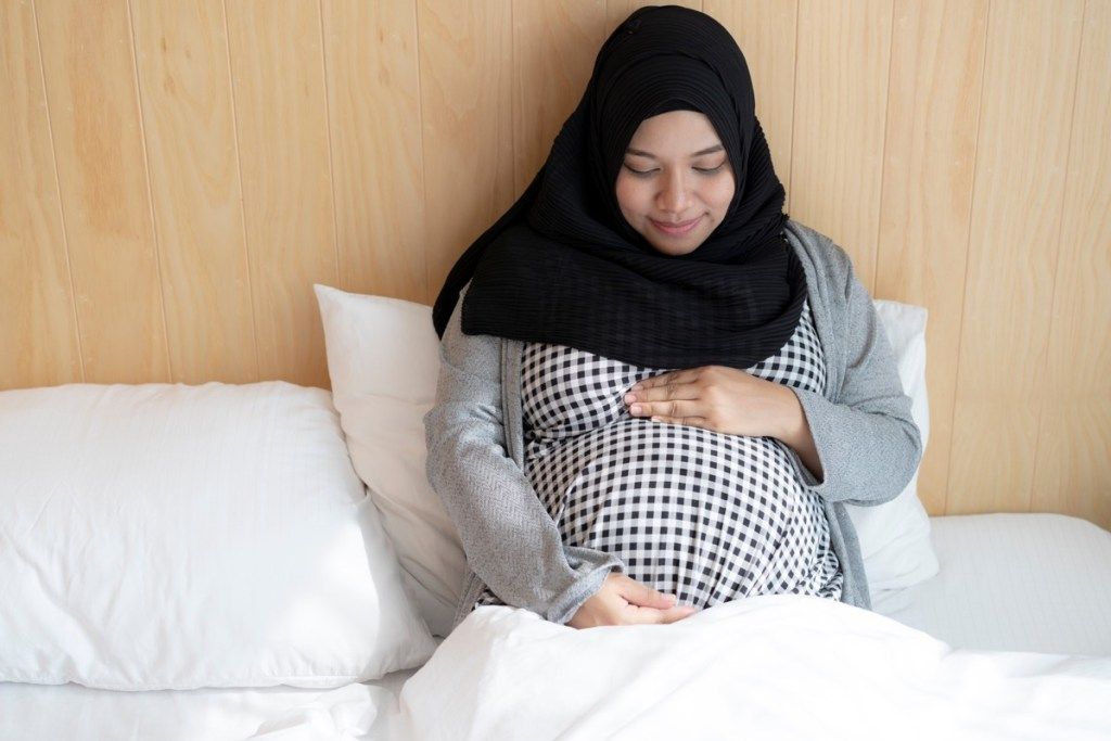 Raskaana oleva musliminainen sängyssä Ramadan
