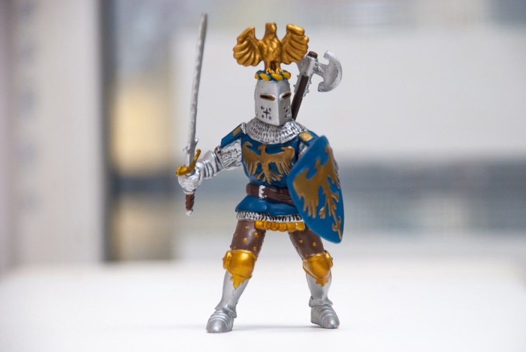 युद्ध कवच पहने हुए और तलवार पकड़े हुए एक आकृति आकृति का खिलौना