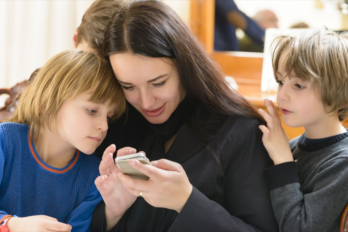 Madre e hijos disfrutando de smartphone