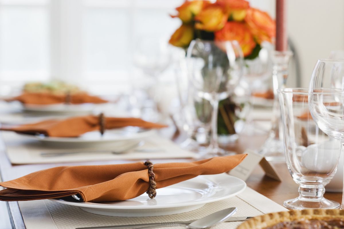 porcelana fina com guardanapos laranja na mesa de jantar de Ação de Graças