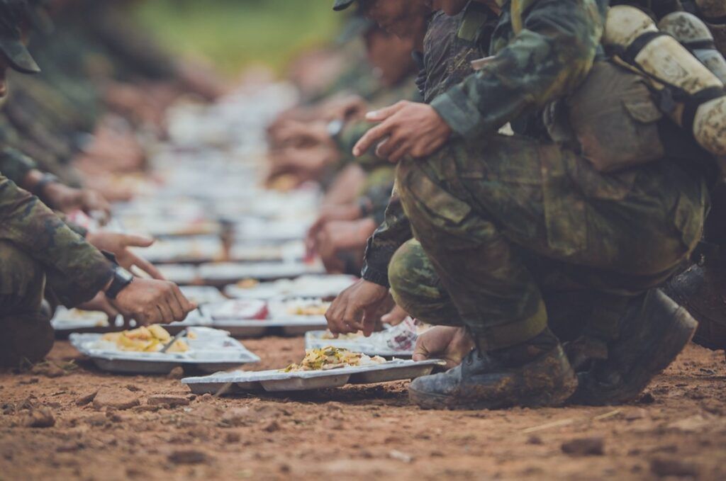 sotilaan kädet ojensivat kädet ja jalat taivutettuina syödessään ruokaa