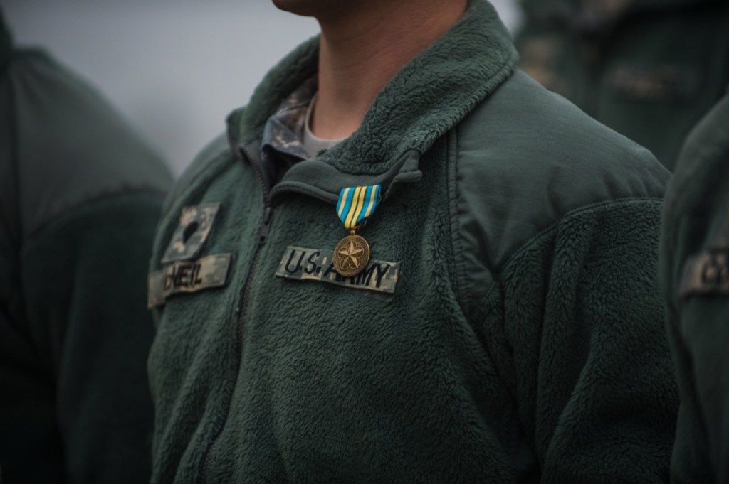krūts militāram vīram, kas valkā zaļu krāsu