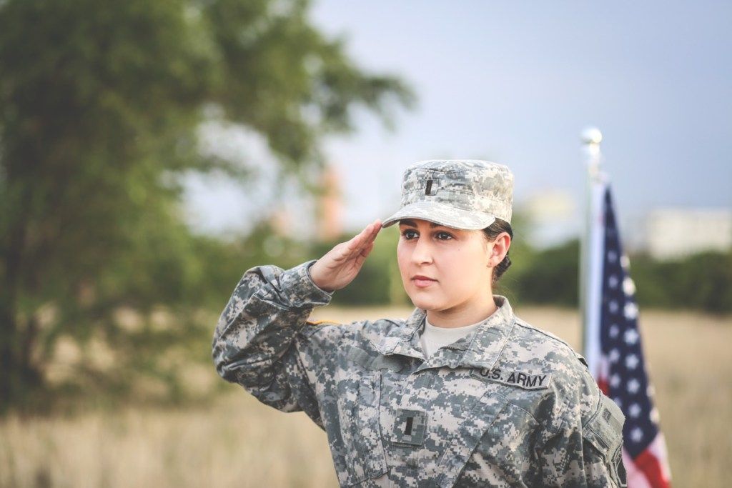 Naispuolinen sotilas, joka tervehtii armeijan slangia