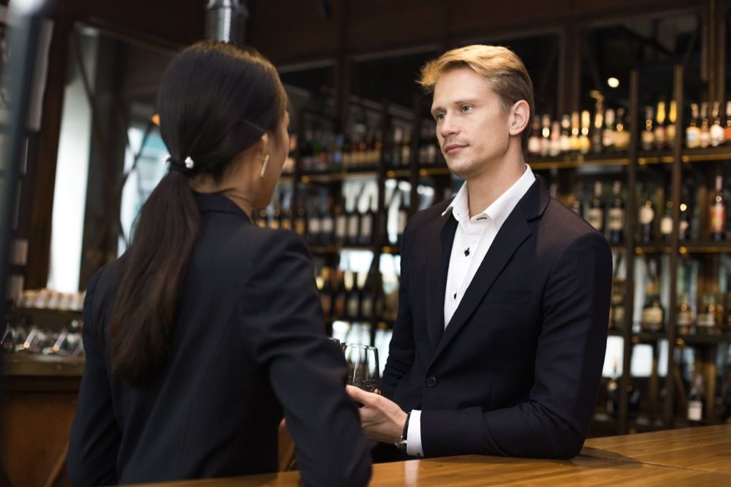 Žena mluví s šéfem v baru