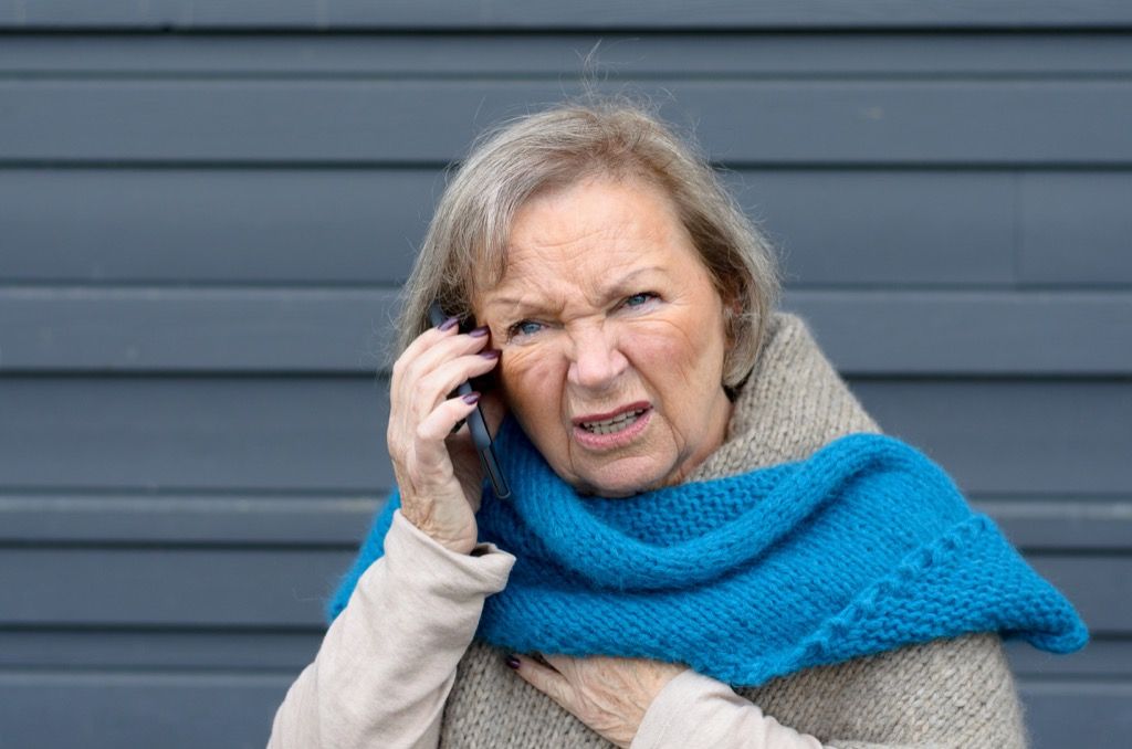 फोन पर बातचीत करते समय बूढ़ी महिला उलझन में है
