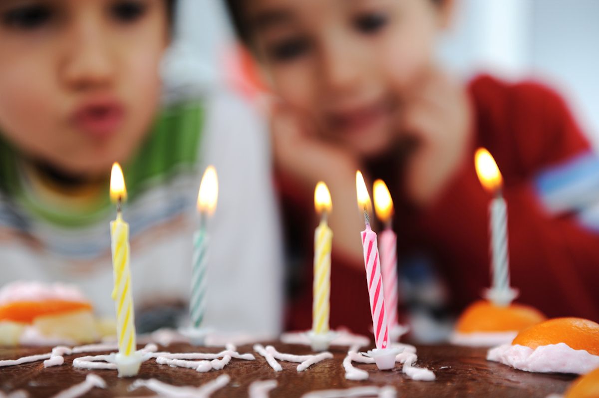 Kaks väikest poissi puhusid sünnipäeval peol tordil küünlaid