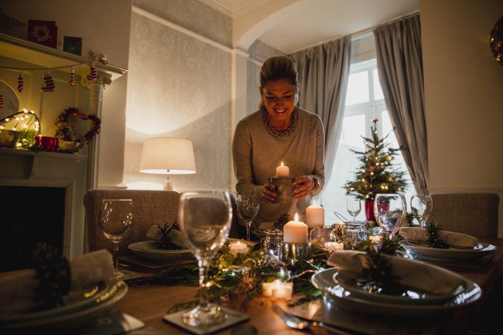 Donna che prepara la tavola con decorazioni festive