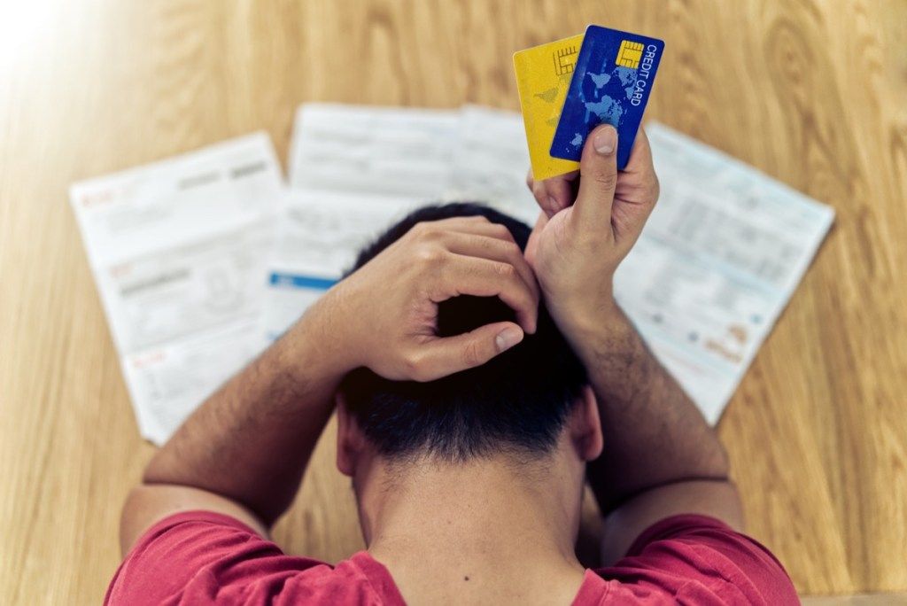 Người đàn ông căng thẳng về các hóa đơn và thẻ tín dụng của mình