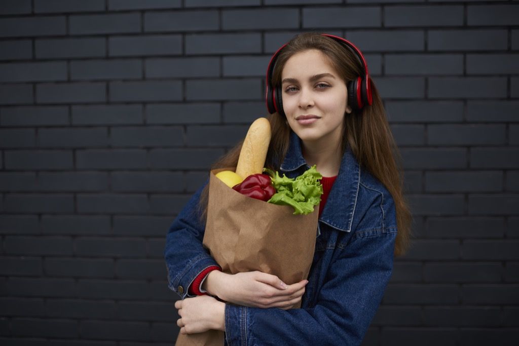 Nainen kuuntelee musiikkia, kun ruokaostosvirheitä