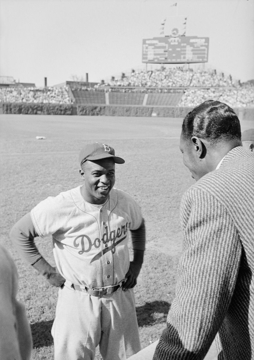Jackie Robinson berbicara dengan Nat King Cole di lapangan
