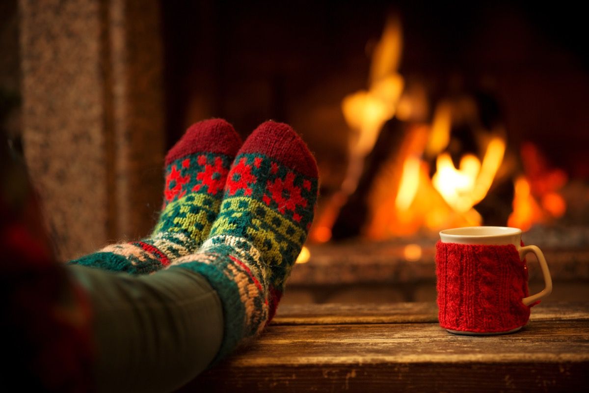 pies en calcetines de lana junto a la chimenea de navidad