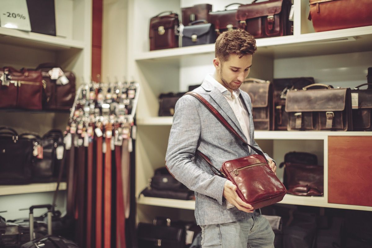 رجل يقف مع حقيبة لا يستطيع تحملها في المتجر