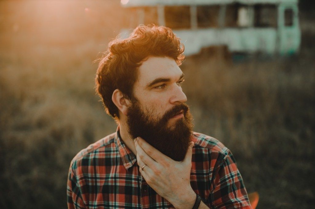 uomo hipster accarezzando la sua barba