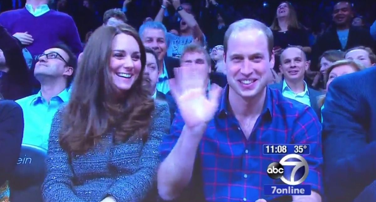Príncipe William acena para a câmera no Barclays Nets Game com Kate Middleton
