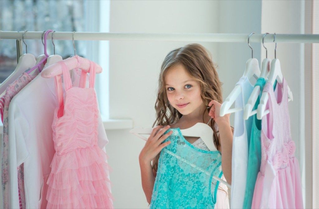 maža mergaitė spintoje, laikanti suknelę spintoje, auklėjimo patarimai
