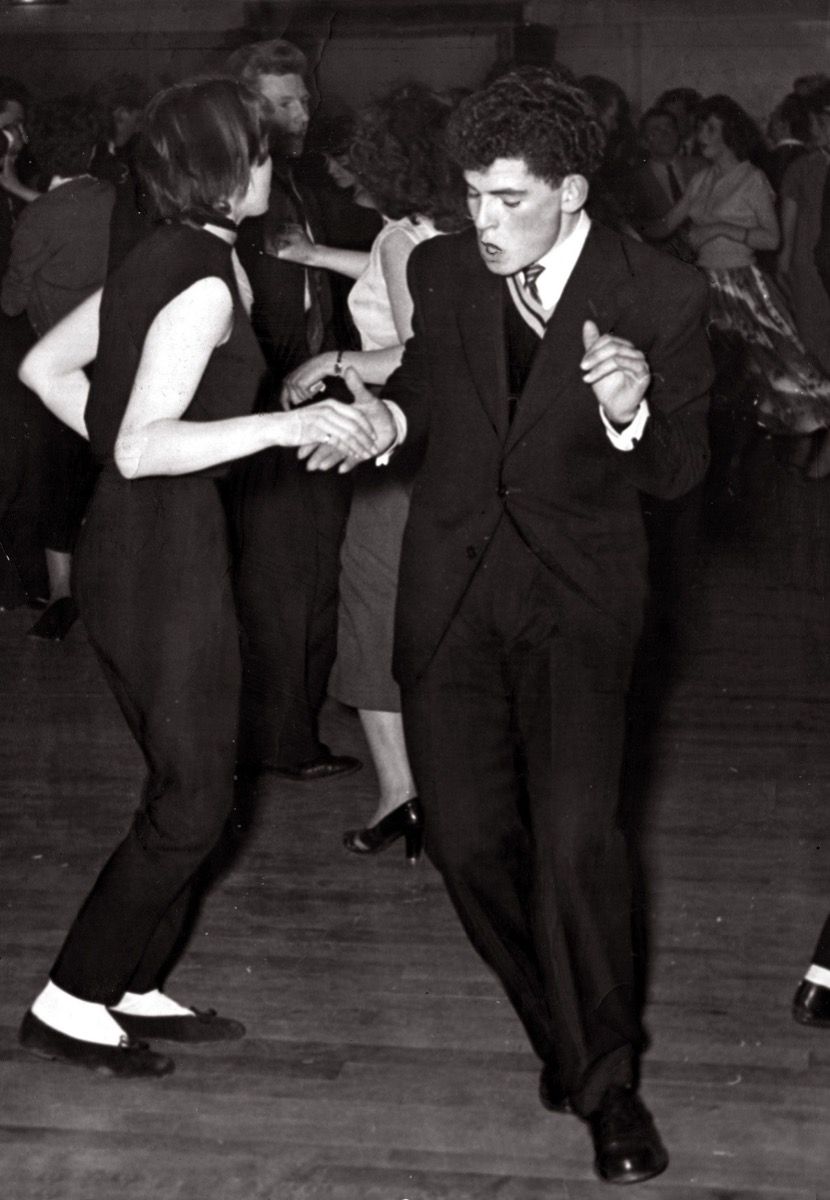 Pasangan muda 1950-an menari jive, datuk dan nenek yang keren