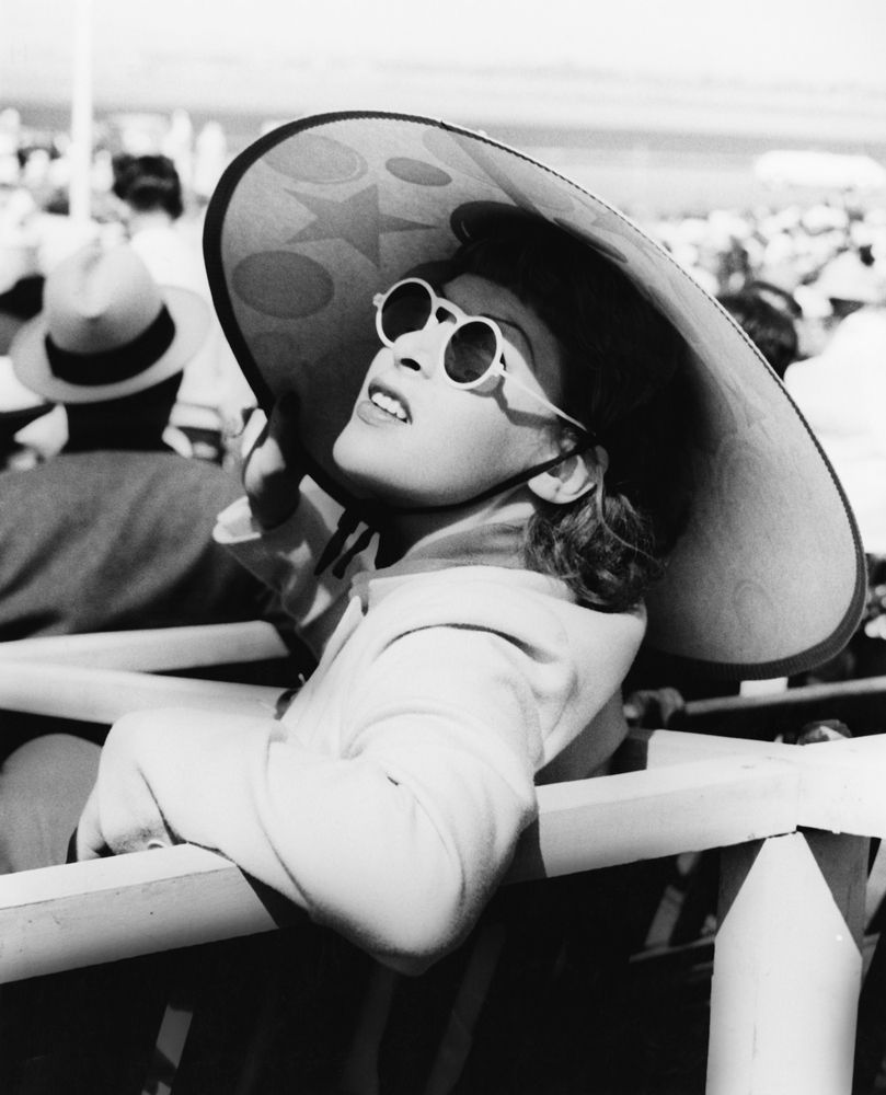 Naine 1940. aastatel suure päikesemütsi ja päikeseprillidega