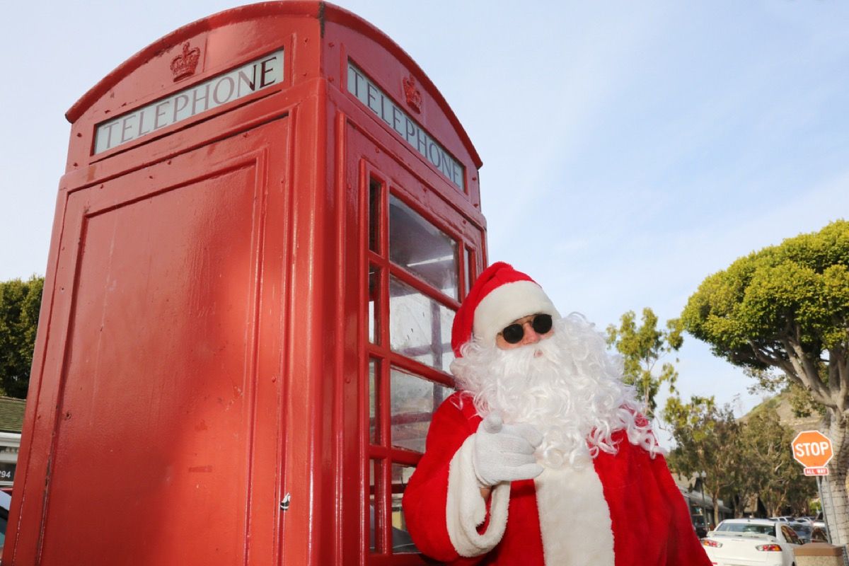 סנטה עומדת עם משקפי שמש בתא הטלפון בלונדון
