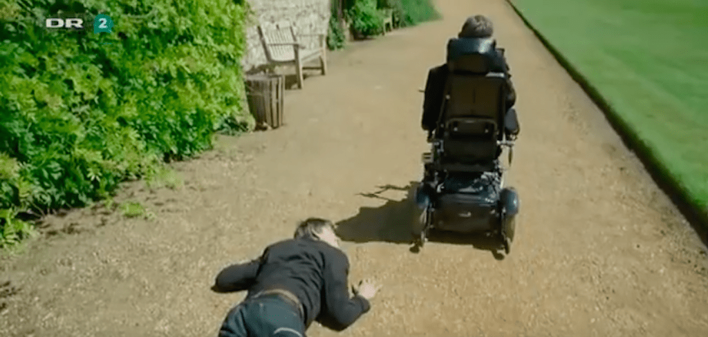 Stephen Hawking beží po Brianovi Coxovi