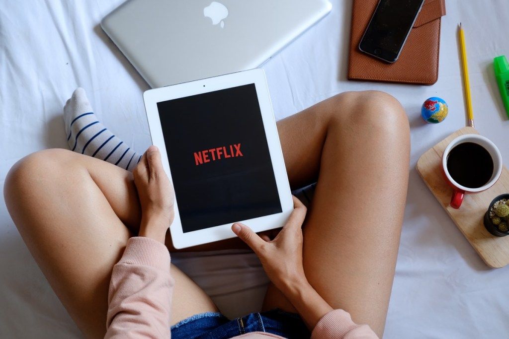 kvinne med iPad som ser på Netflix