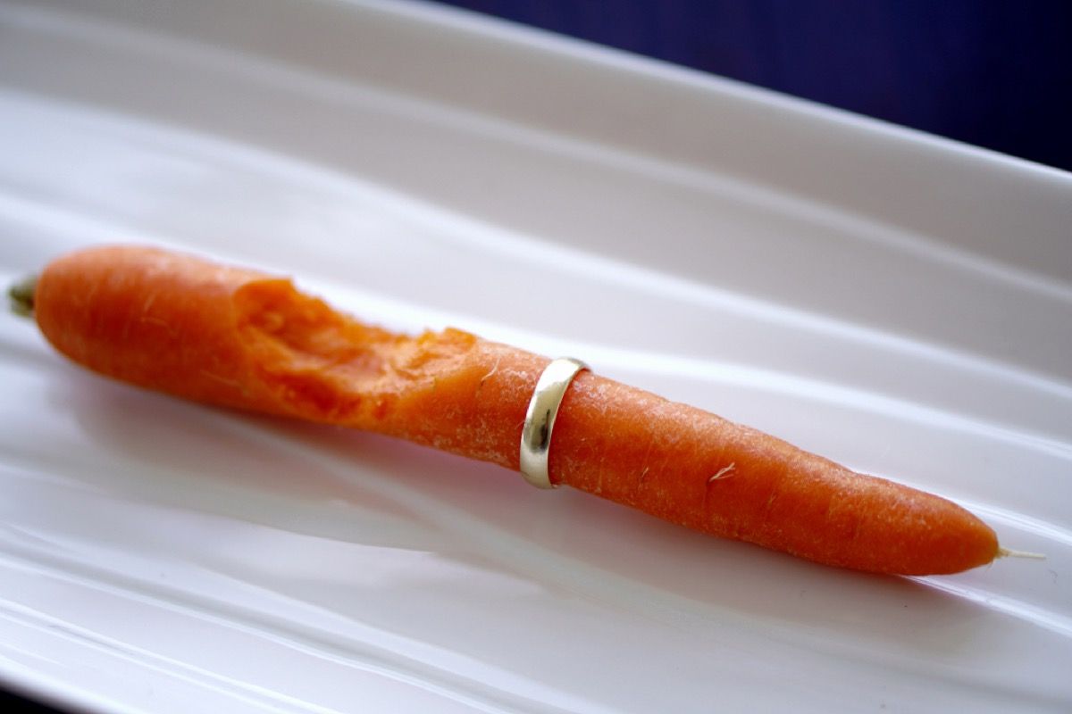 una zanahoria con un anillo de oro y un bocado sacado de la zanahoria