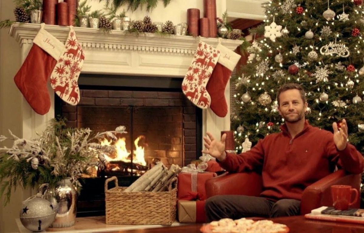 Kirk Cameron delante de la chimenea en ropa de Navidad para salvar la Navidad
