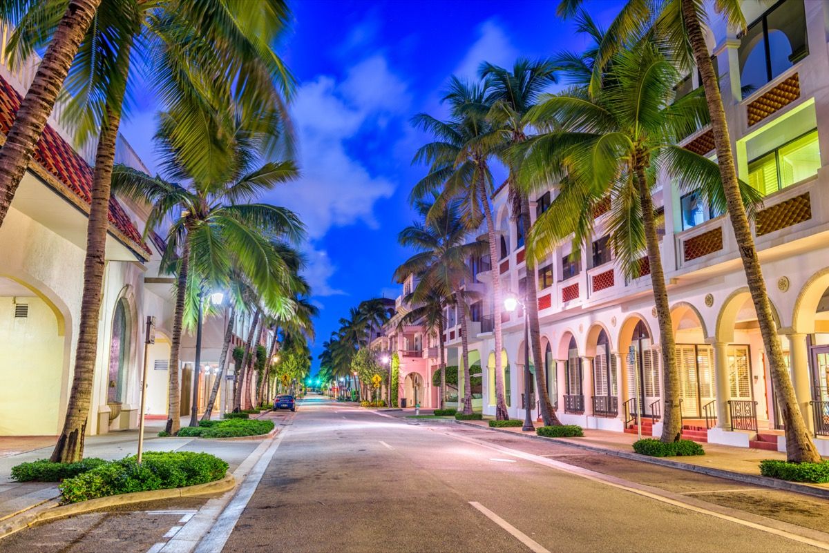 prázdna ulica, palmy a biele budovy v Palm Beach na Floride v noci