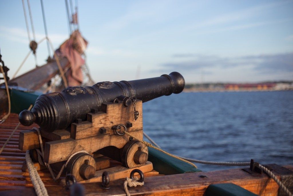 Старая пушка на корабле направлена ​​в воду