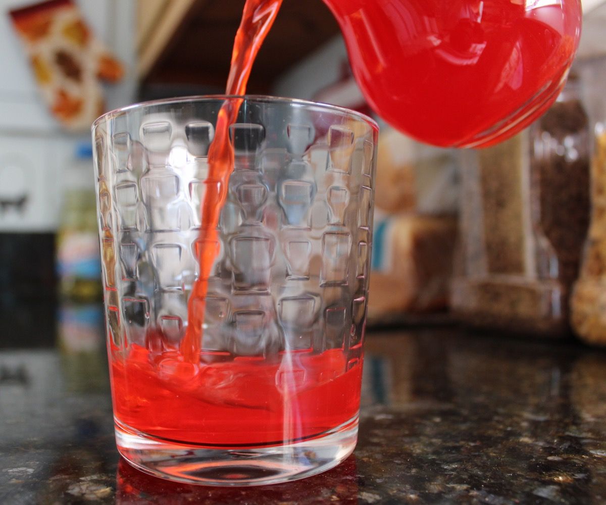 beguda vermella kool-aid que s’aboca en un got
