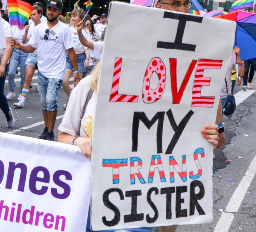 女性は、プライドのお祝いからニューヨーク市のプライド写真でトランス姉妹をサポートするサインを保持します