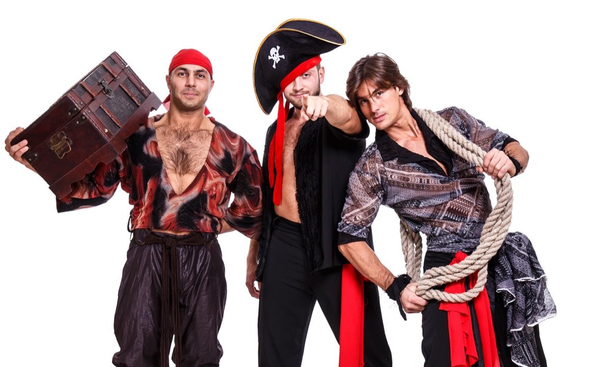 Tri muškarca odjevena u pirate sa šeširima, šalovima i užetom