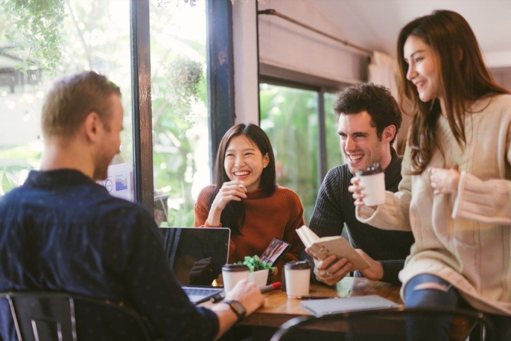 Groep vrienden chatten en laptop gebruikt in café in de coffeeshop
