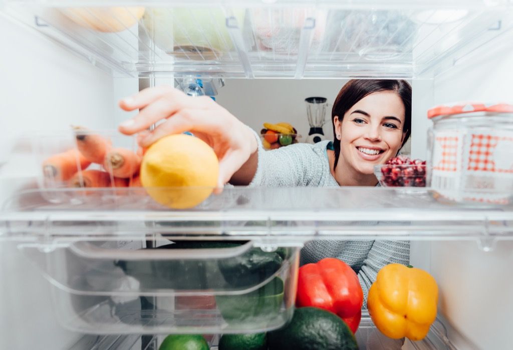 nainen tavoittaa ruokaa jääkaapissa