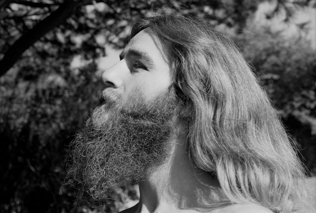 Porträtt av 1970-talets hippie man med skägg och långt hår som är andligt i Berkeley, Kalifornien på 1970-talet