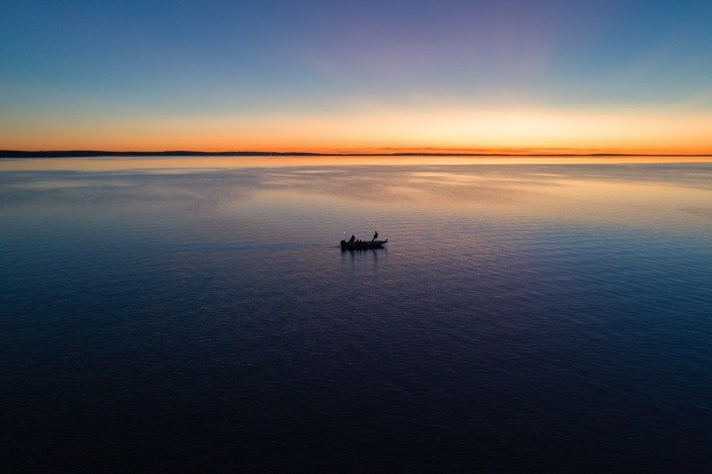 Mała łódź rybacka na jeziorze Houghton w stanie Michigan o wschodzie słońca - obraz