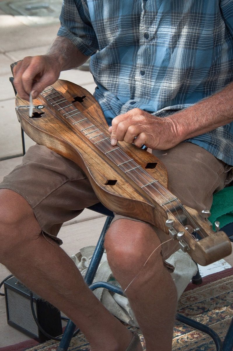 ダルシマー楽器を演奏する男、厳しい状態の事実