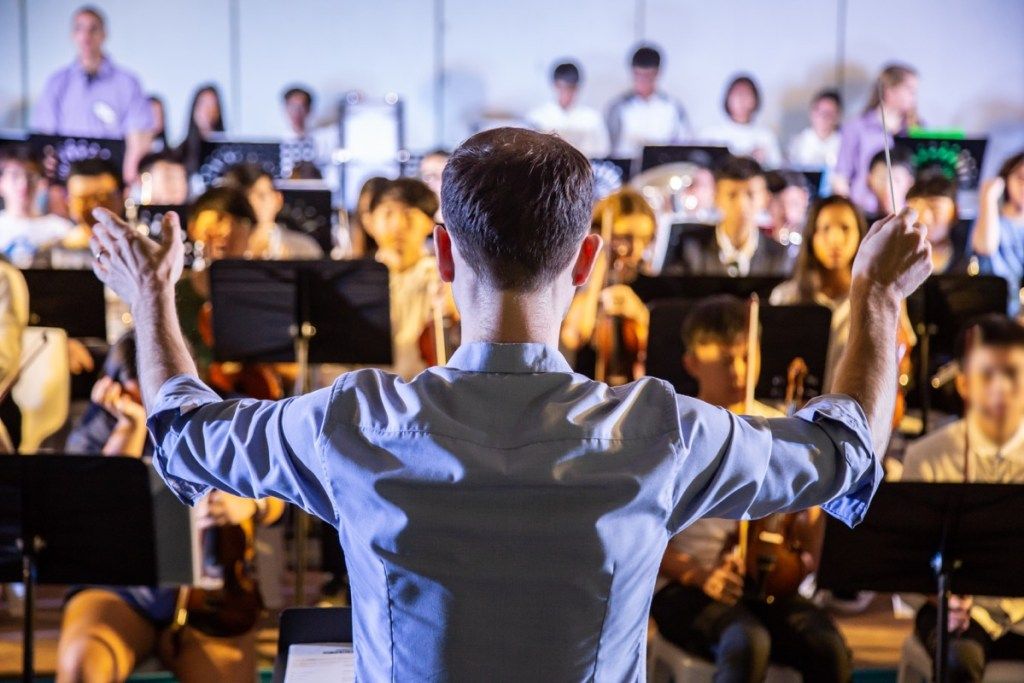 um maestro conduzindo uma banda orquestral escolar