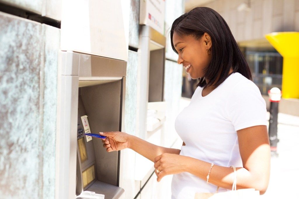 nuori nainen pankkiautomaatissa