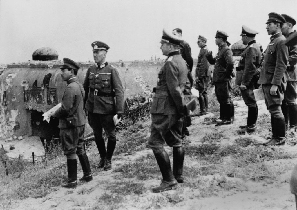 Japonijos pareigūnai tikrina „Maginot Line“ po Vokietijos pralaimėjimo Prancūzijai 2 pasauliniame kare. Jie apžiūri sugadintą įėjimą į sudėtingus Schoenenbourgo įtvirtinimus. 1940 m. Rugsėjo 26 d