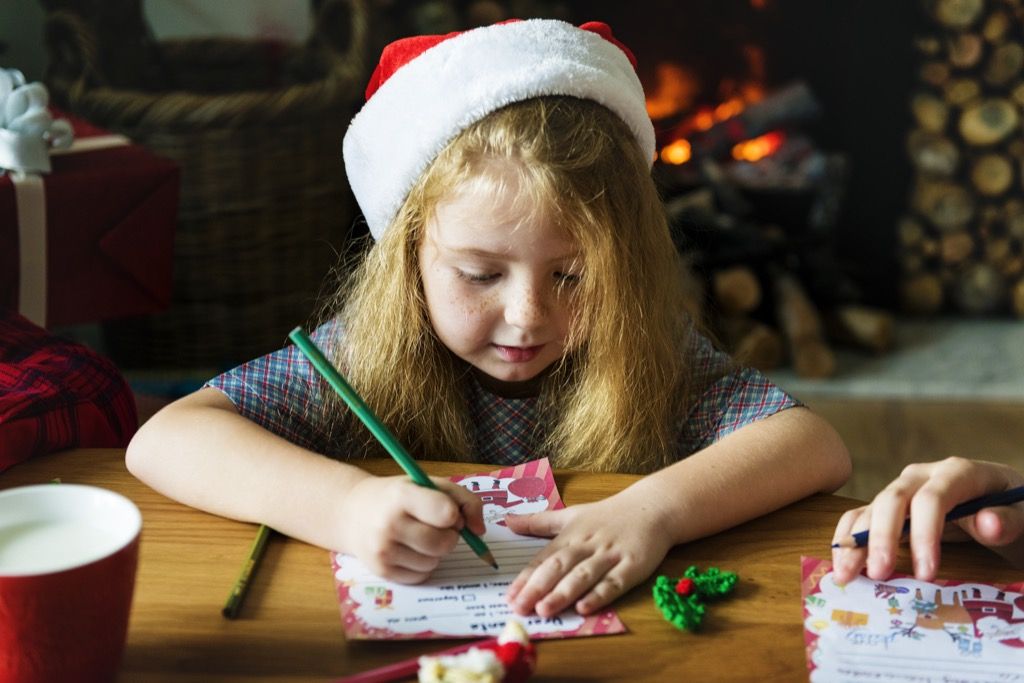 Maža mergaitė rašo laišką Kalėdų seneliui