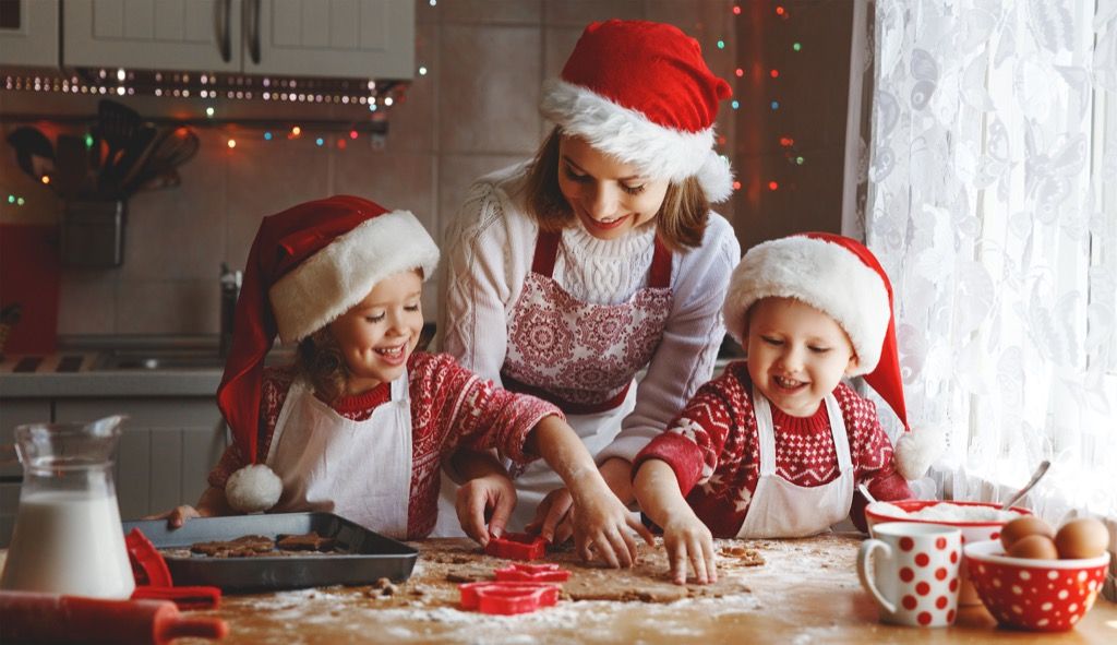 Otroci, ki z mamo pripravljajo božične piškote