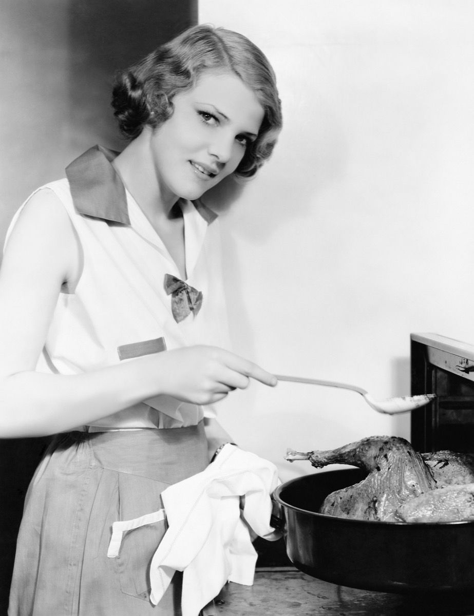 Foto de época de una mujer en la cocina cocinando un pollo {Fecha de hace 50 años}