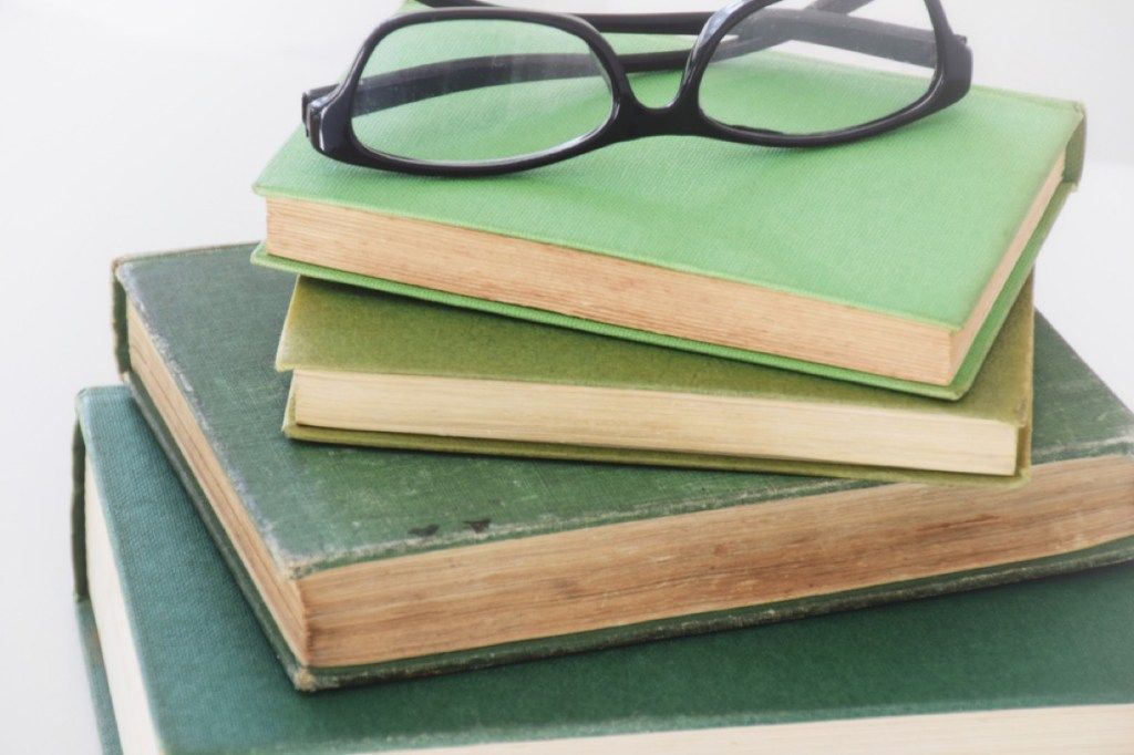 žalios knygos, sukrautos su akiniais viršuje, Džoana gauna patarimų