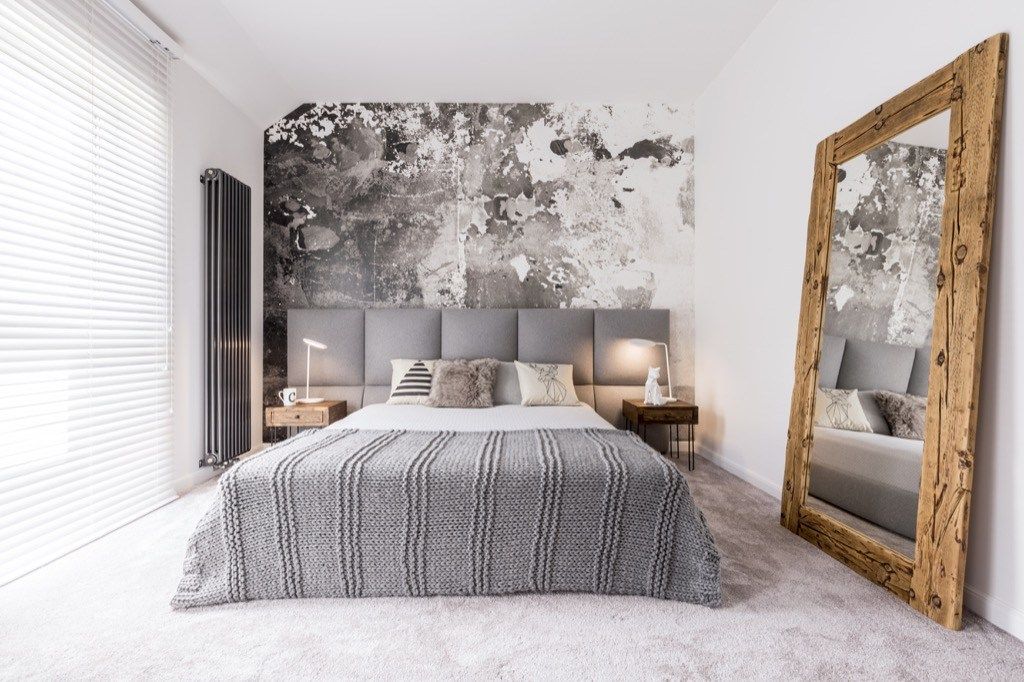 mažas, gerai suprojektuotas vienspalvis modernus miegamasis su mediniu veidrodžiu prie sienos, patarė Joanna Gaines