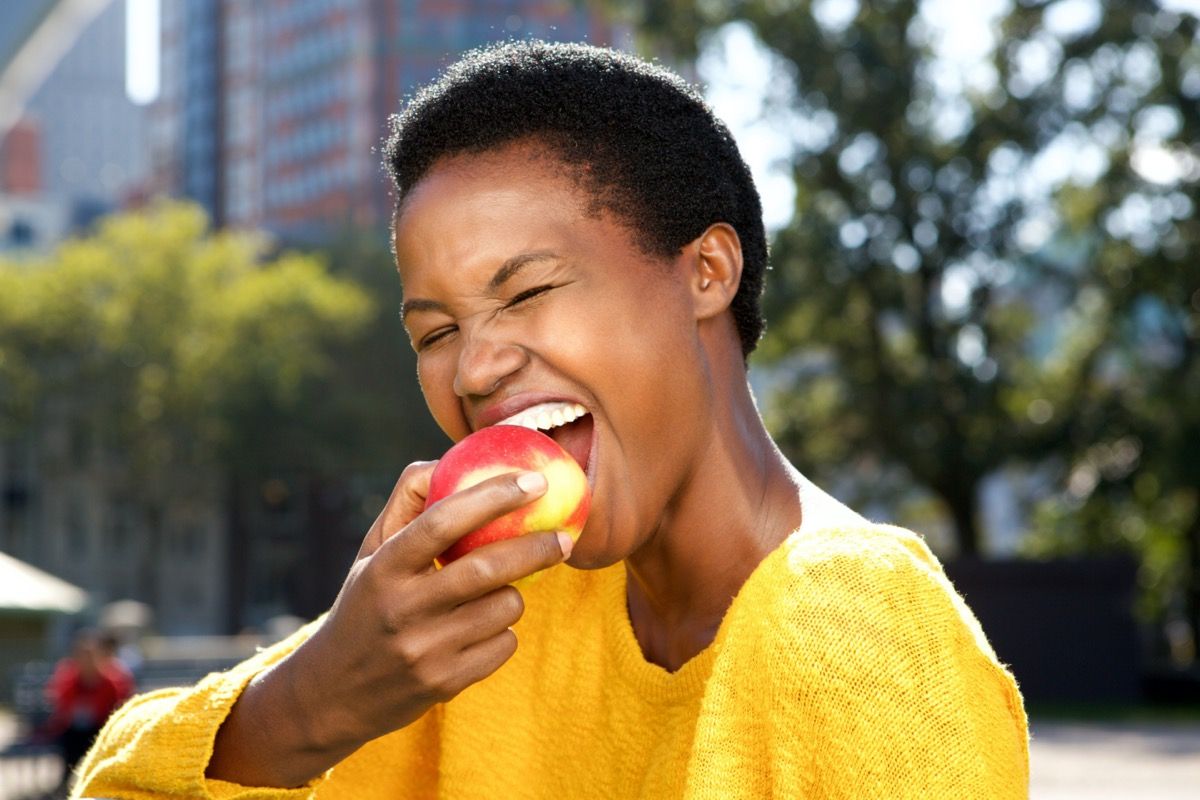 Joven negra comiendo una manzana
