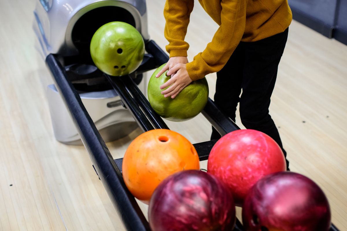 Gros plan des mains saisissant la balle au bowling