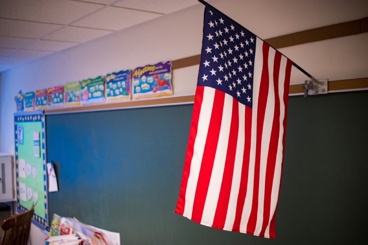 教室の黒板の上にぶら下がっているアメリカの国旗のクローズアップ