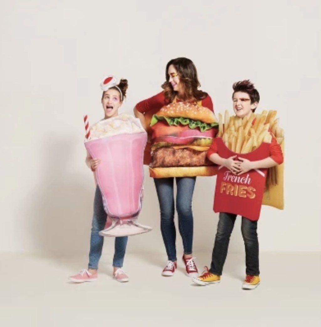 moteris, apsirengusi hamburgeriu, mergina - rožiniu pieno kokteiliu, o berniukas - bulvytėmis, bulvytėmis, šeimos Helovino kostiumais
