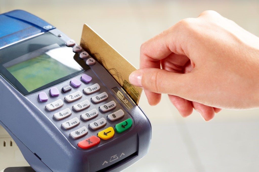 person som sveper sitt kreditkort