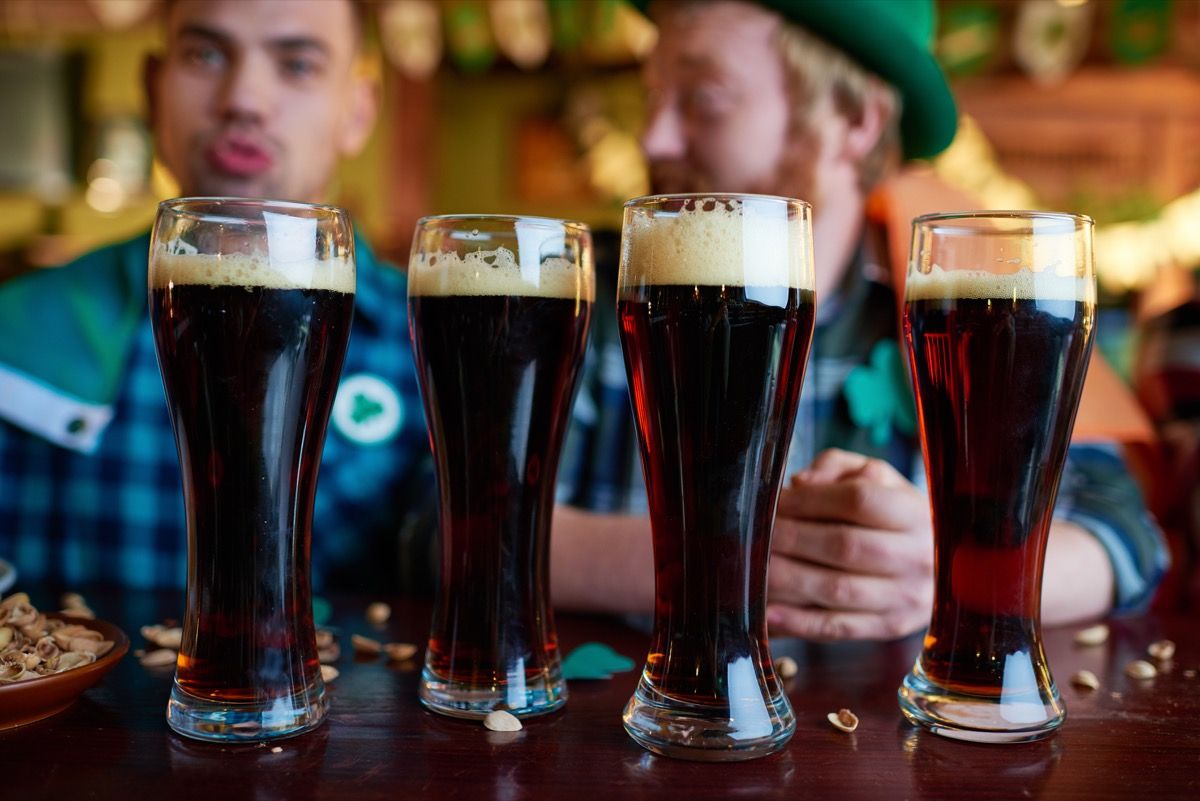Cận cảnh một cốc bia đen đầy bọt được đặt trên bàn có vỏ hạt